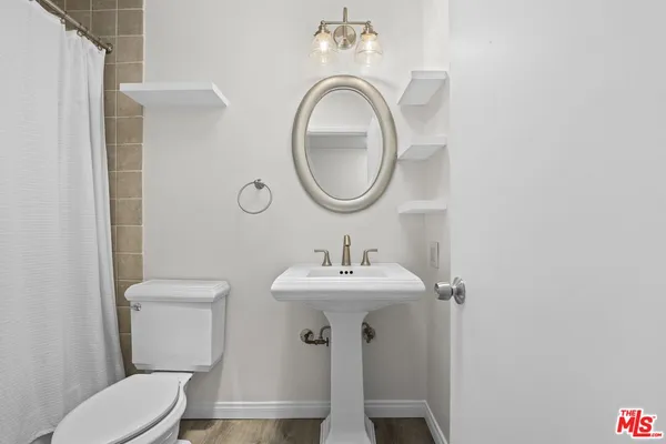 a bathroom with a toilet sink and mirror