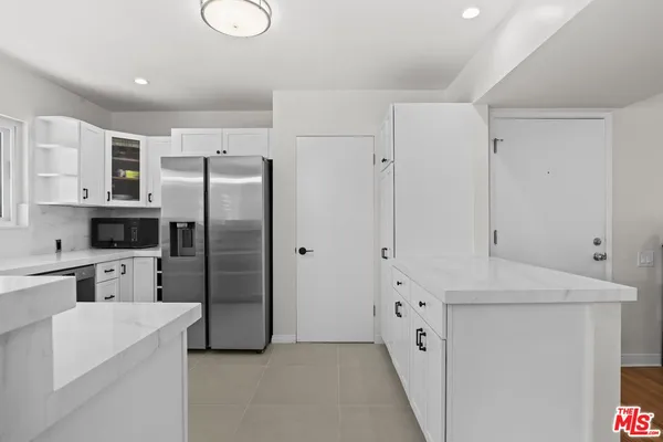 a kitchen with stainless steel appliances a refrigerator sink and cabinets