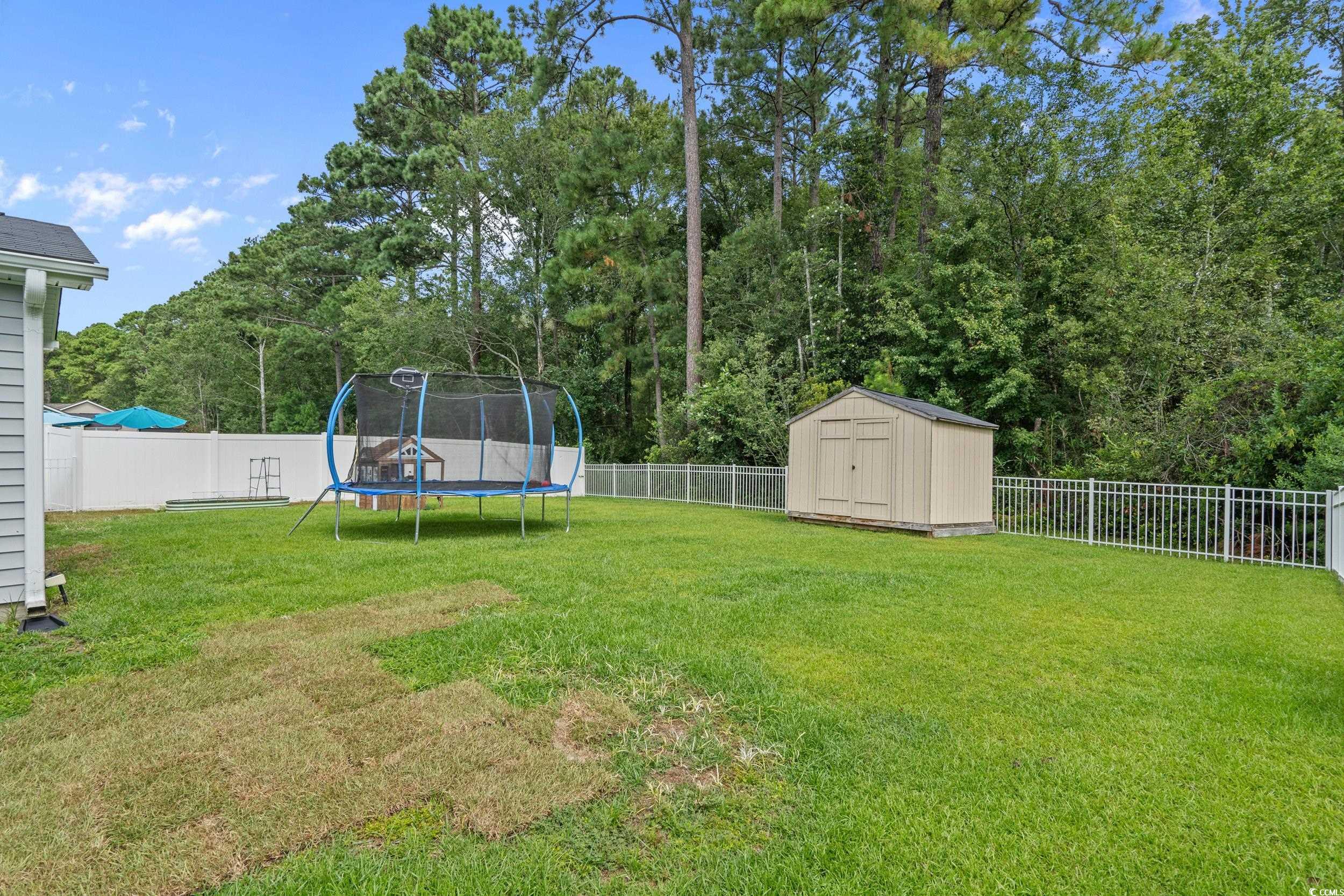 733 Old Castle Loop Myrtle Beach, SC 29579 - Photo 35 of 39 Fenced backyard with a trampoline and a storage un
