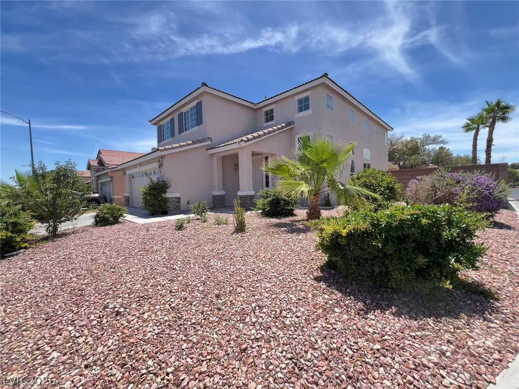 9891 Ridge Hill Avenue Las Vegas, NV 89147 - Photo 2 of 29 A desert-friendly landscape surrounds this welcoming two-story residence, offering both charm and easy maintenance.