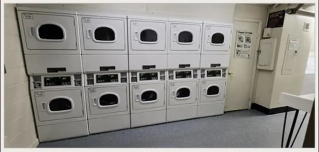 a view of kitchen with stainless steel appliances wooden cabinets washer and dryer