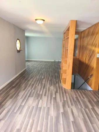 a view of a room with wooden floor and window
