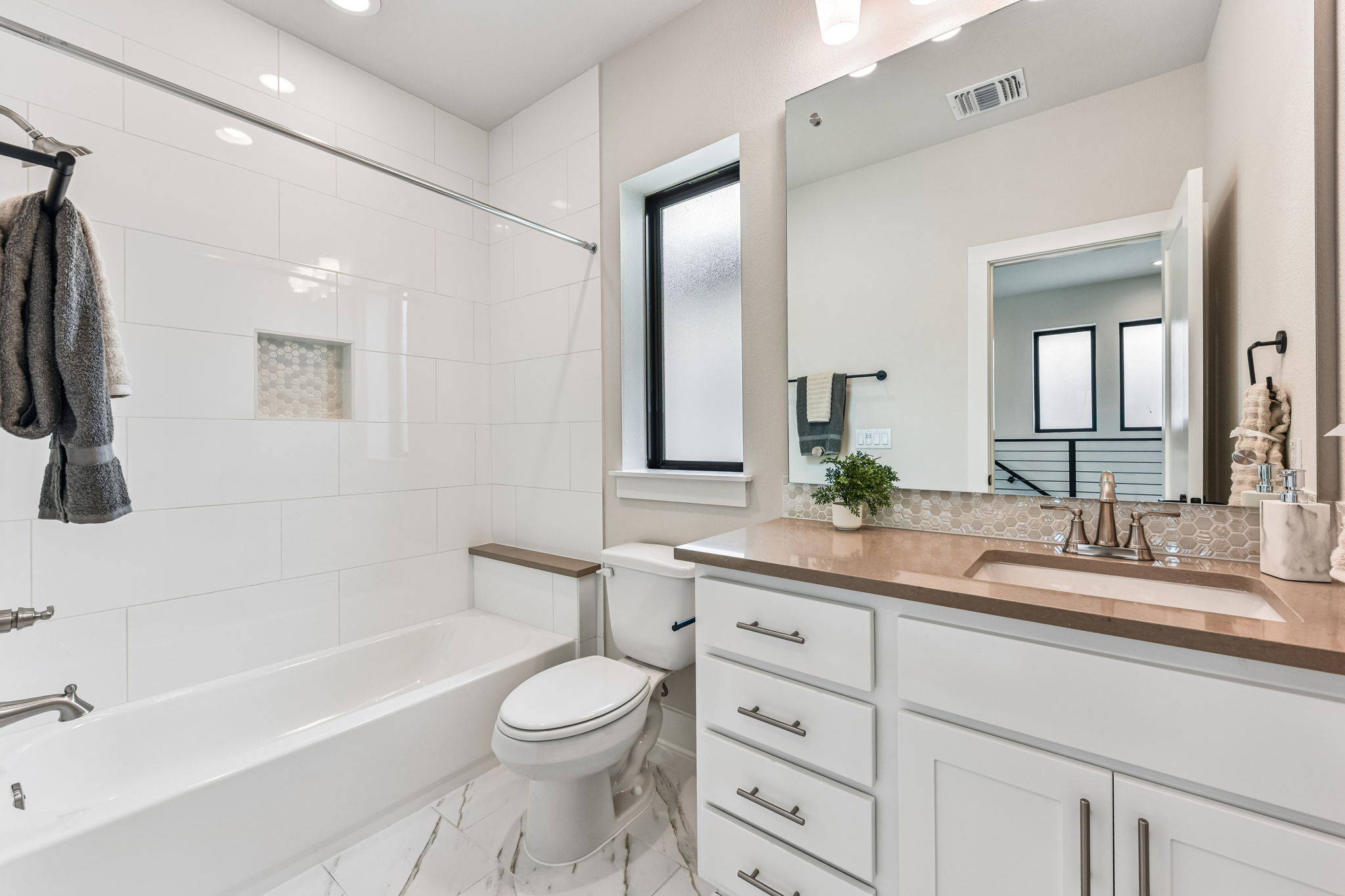 9033 Cattle Baron Path Austin, TX 78747 - Photo 34 of 40 A well-appointed bath features elegant white tiling and a spacious vanity with a contemporary basin.
