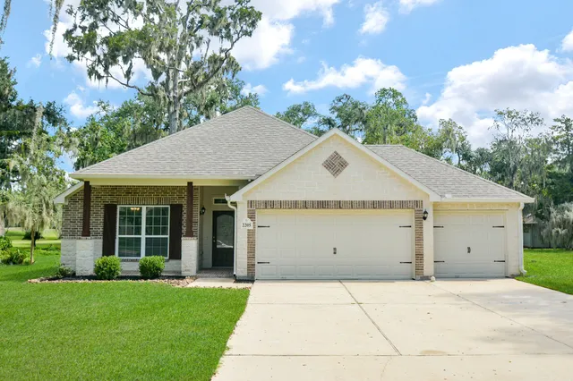 a view of a house with a yard and garage
