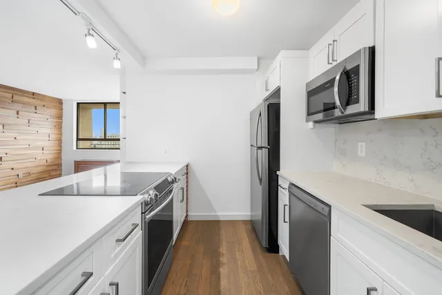 a kitchen with stainless steel appliances white cabinets and a sink