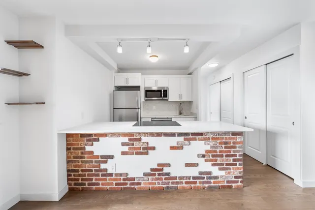 a large white kitchen with kitchen island granite countertop a stove and a sink