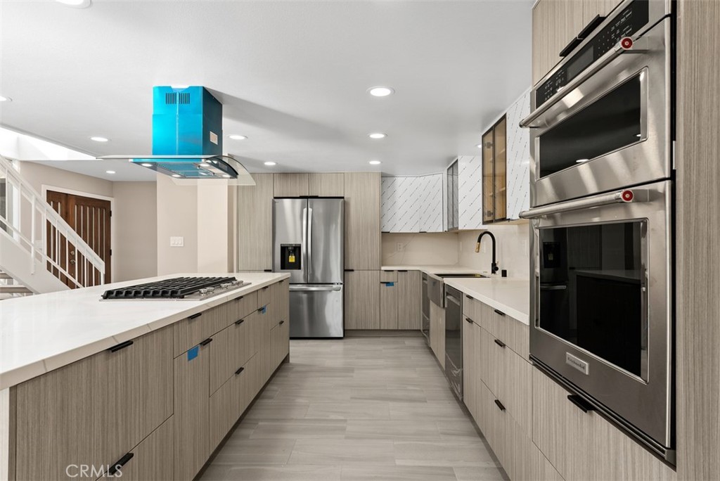 54 Oak Tree Lane Irvine, CA 92612 - Photo 11 of 40 a kitchen with stainless steel appliances granite countertop a stove top oven a sink dishwasher a refrigerator and a oven with wooden floor