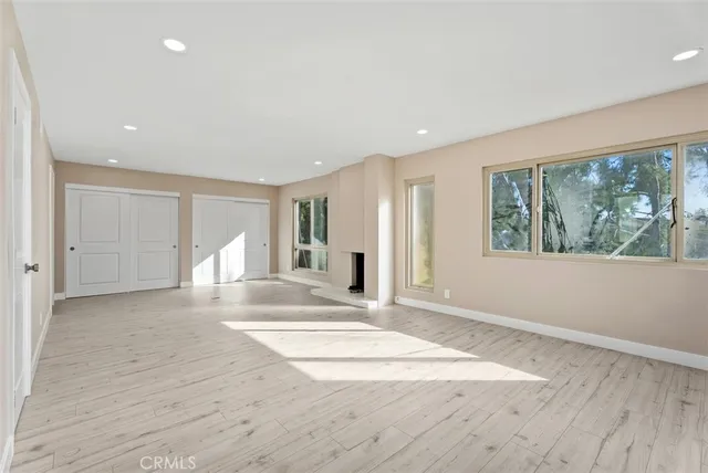 a view of an empty room with a window and front door