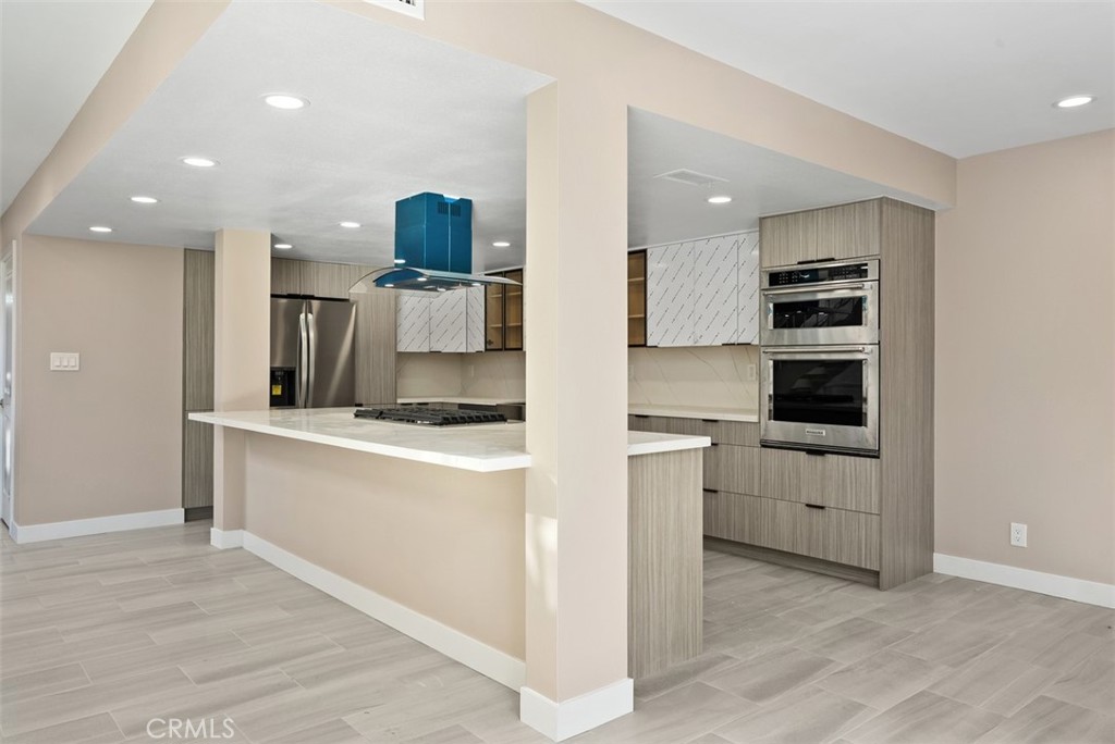 54 Oak Tree Lane Irvine, CA 92612 - Photo 9 of 40 a kitchen with white cabinets and stainless steel appliances