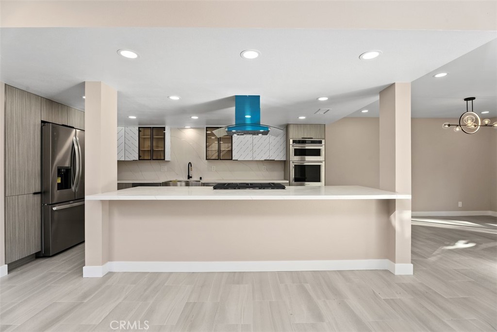 54 Oak Tree Lane Irvine, CA 92612 - Photo 10 of 40 a large kitchen with stainless steel appliances a large counter top a refrigerator and a sink