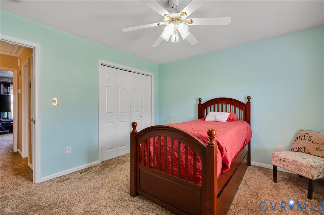 5280 West Quaker Road Disputanta, VA 23875 - Photo 30 of 33 a bedroom with a bed and a chandelier