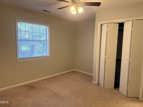 an empty room with windows and closet
