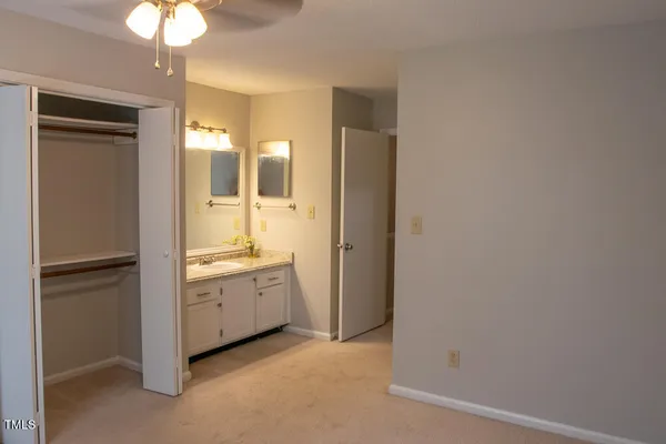 an empty room with a window and a ceiling fan
