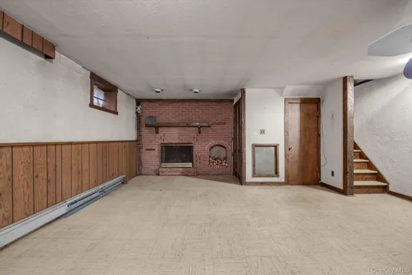 a view of an empty room with a fireplace and a window