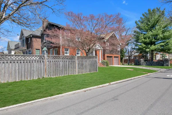 a view of a house with a yard and large trees