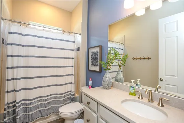 a bathroom with a sink a toilet and shower curtain