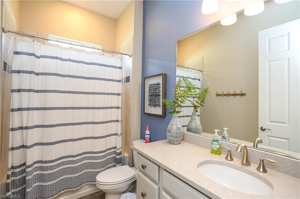 14656 Kelson Circle Naples, FL 34114 - Photo 18 of 50 a bathroom with a sink a toilet and shower curtain