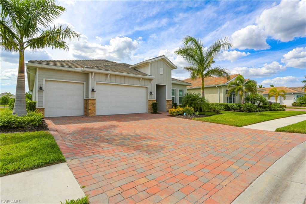 14656 Kelson Circle Naples, FL 34114 - Photo 2 of 50 a view of a white house with a big yard plants and palm trees