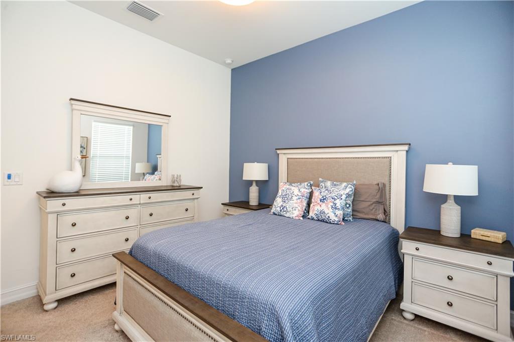 14656 Kelson Circle Naples, FL 34114 - Photo 21 of 50 a bedroom with a bed and a mirror on dresser