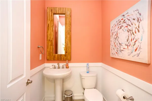 a bathroom with a toilet sink and mirror