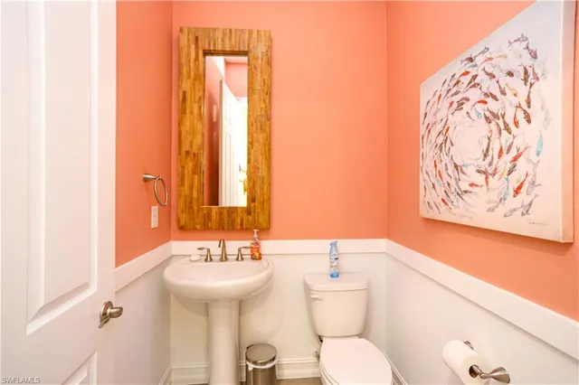 a bathroom with a toilet sink and mirror