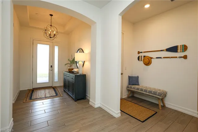 a view of hallway with window and wooden floor