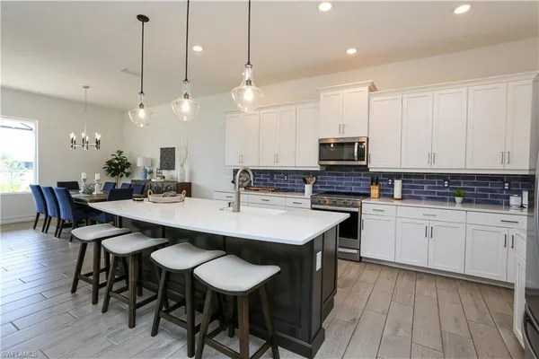 a kitchen with kitchen island granite countertop a sink and a stove top oven with wooden floor