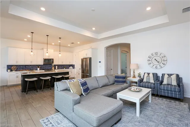 a living room with furniture a rug and kitchen view