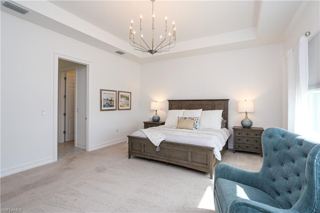 14656 Kelson Circle Naples, FL 34114 - Photo 45 of 50 a bedroom with a large bed couch and chandelier