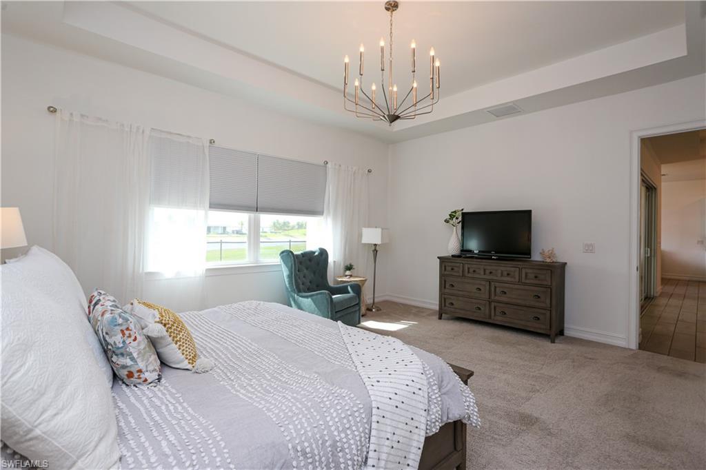 14656 Kelson Circle Naples, FL 34114 - Photo 47 of 50 a bedroom with a bed and a flat tv screen on the dresser
