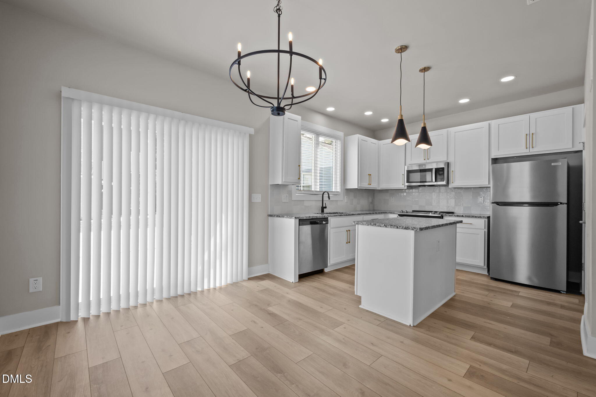 421 Eugene Street, Unit A Durham, NC 27701 - Photo 14 of 38 a kitchen with stainless steel appliances granite countertop a refrigerator a stove a sink and white cabinets with wooden floor