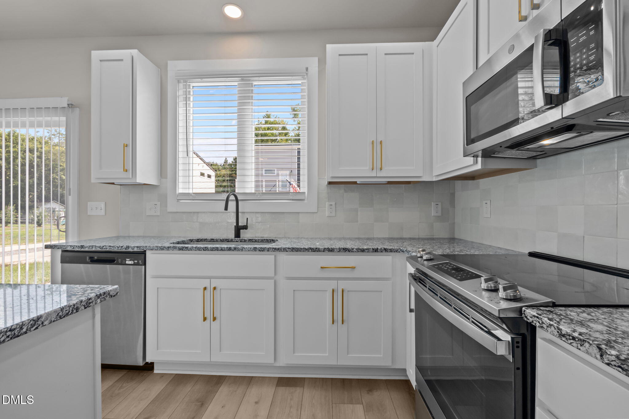 421 Eugene Street, Unit A Durham, NC 27701 - Photo 17 of 38 a kitchen with stainless steel appliances granite countertop a sink stove and cabinets