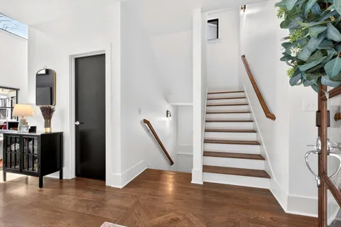 a kitchen with a stove a sink and a living room view