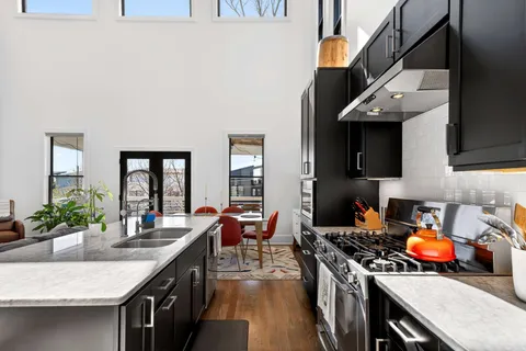 a kitchen with stainless steel appliances granite countertop a stove a sink dishwasher and cabinets with wooden floor