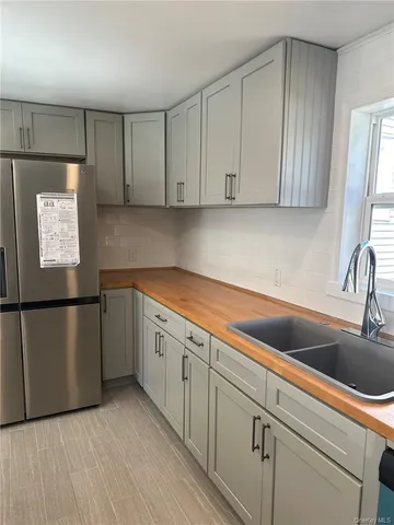 a kitchen with a refrigerator sink and cabinets