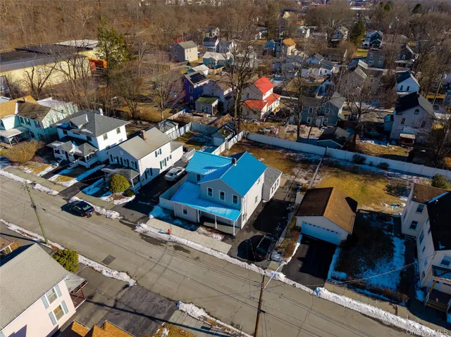 an aerial view of a houses with parking
