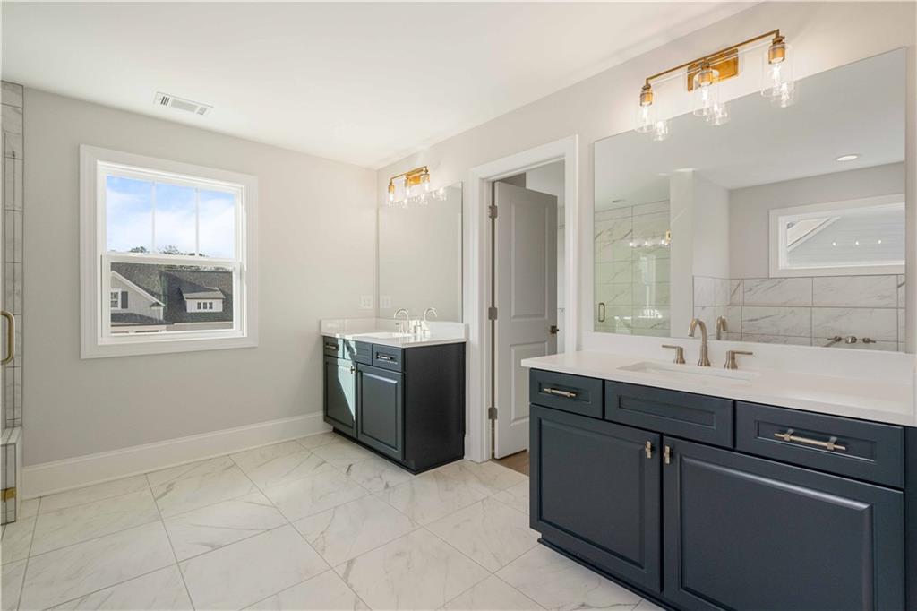 126 Spaulding Lane Woodstock, GA 30188 - Photo 24 of 48 a spacious bathroom with a double vanity sink a mirror and a bathtub