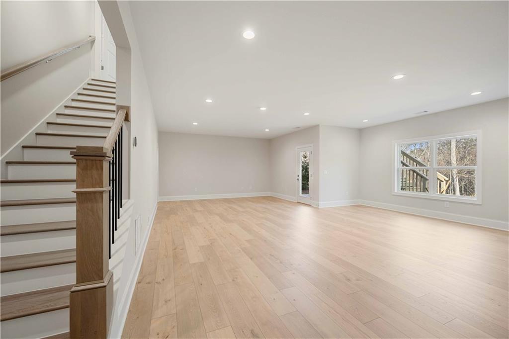 126 Spaulding Lane Woodstock, GA 30188 - Photo 34 of 48 a view of an empty room with wooden floor and stairs