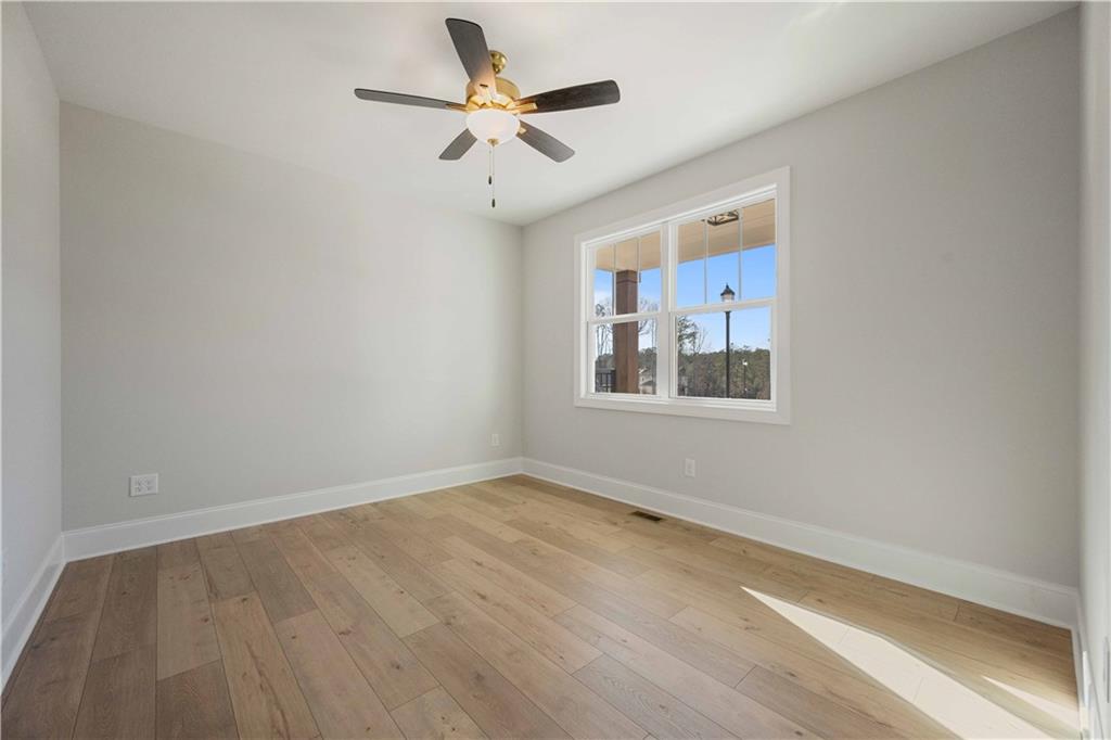 126 Spaulding Lane Woodstock, GA 30188 - Photo 6 of 48 an empty room with a window and a fan