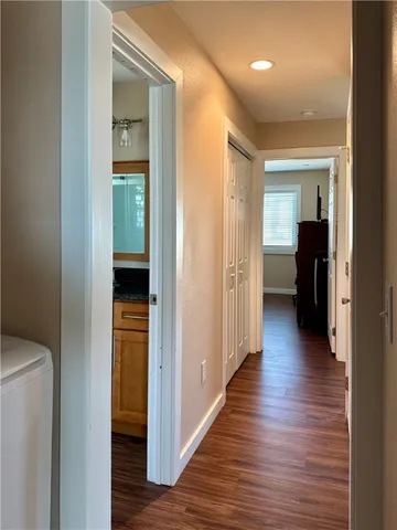 a view of a hallway with wooden floor and closet