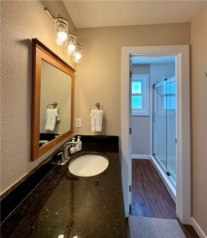 a bathroom with a sink a mirror and a shower