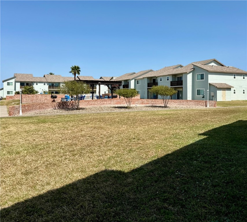 230 Cut-Off Road, Unit B107 Port Aransas, TX 78373 - Photo 23 of 25 a view of swimming pool with lawn chairs and large trees