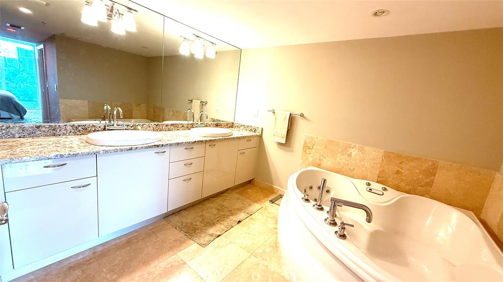 45 Hendricks Isle, Unit 403 Fort Lauderdale, FL 33301 - Photo 10 of 26 a bathroom with a tub sink and mirror