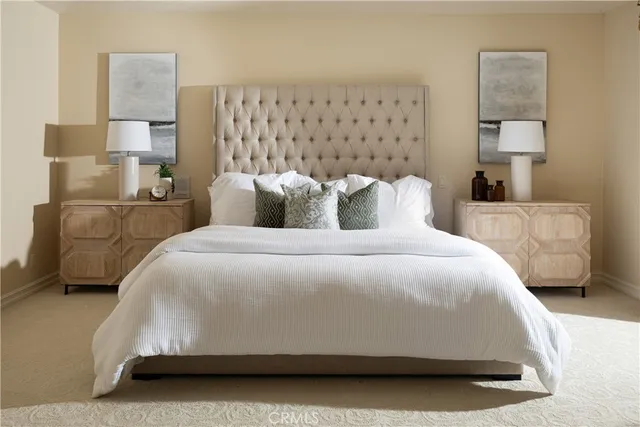 a large bed sitting in a bedroom next to a lamp