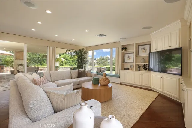 a living room with furniture large window and flat screen tv