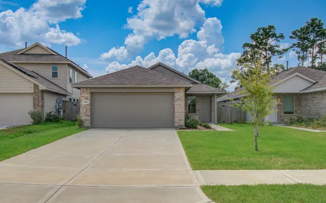 a front view of a house with a yard and garage