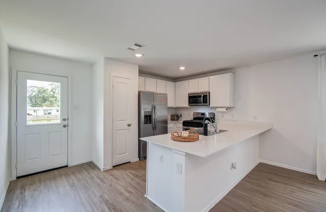 a kitchen with refrigerator cabinets and wooden floor