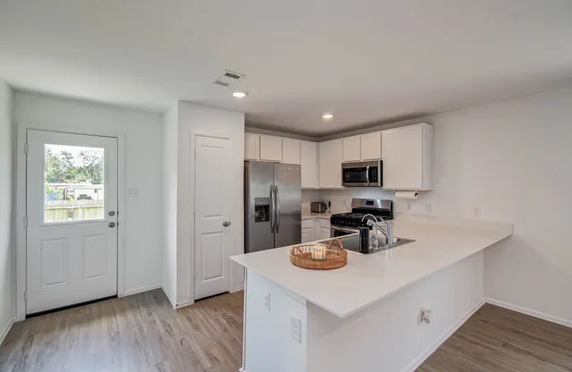 a kitchen with refrigerator cabinets and wooden floor