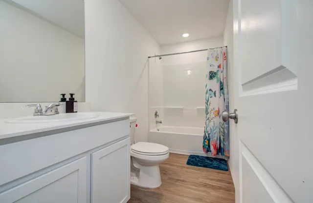 a bathroom with a sink a toilet and a large mirror
