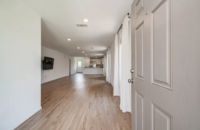 a view of a hallway with wooden floor and staircase